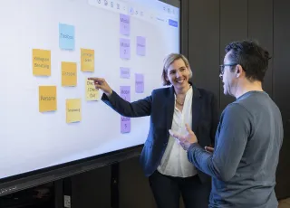 zwei Personen am Bildschirm in Seminarraum eins an der katholischen Journalistenschule ifp